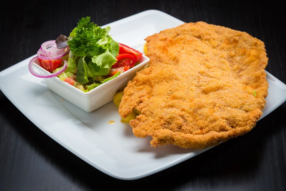 BookNoFees: Örnek fotoğraf: Beyaz tabakta yanında salatayla pane şnitzel