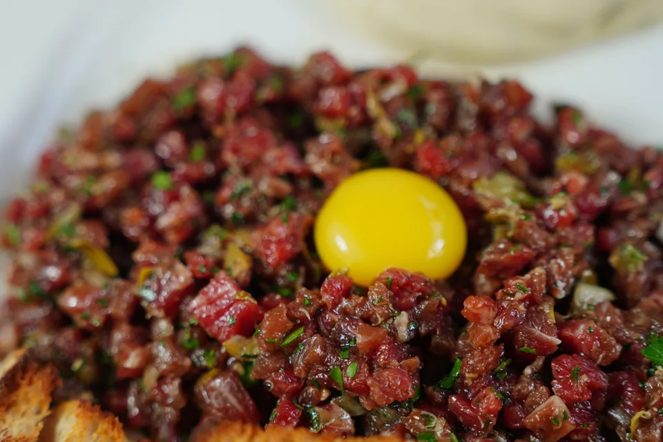 BookNoFees: Örnek fotoğraf: Yumurta sarısıyla süslenmiş, kızarmış ekmekle servis edilen dana tartar